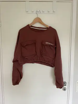 Cropped sweatshirt, strl 42, från Bohoo. Vinröd mot det bruna hållet. Använd ett fåtal ggr. Fint skick.