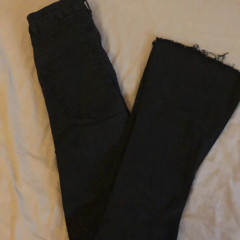 Ett par svarta bootcut jeans från Gina tricot, har hål på båda knäna  och är i ganska bra skick . Jeans & Byxor.