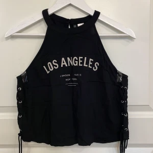 Sött linne  - Säljer detta söta svarta linne med snören i sidorna. 