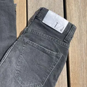 Ett par tighta gråsvarta jeans från tiger of sweden