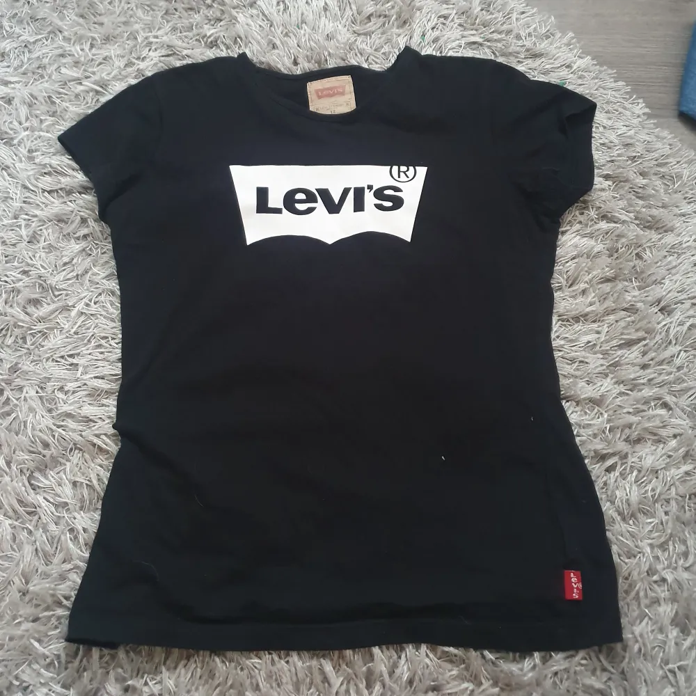 Säljer en snygg svart tröja från Levi's🥰 köpt för många år sen, men knappt blivit använd, så i nyskick🥰Ingen aning vad den är köpt för då det var en present, men säljer billigt då jag behöver bli av med allt jag inte använder💕. T-shirts.