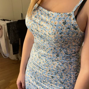 Ljusblå blommig klänning - Ljusblå blommig klänning med snörning, säljer för att den är för stor för mig🥲 fint skick i storlek 38/M. Köpare står för frakt, tryck inte ”köp nu” utan kontakta ist🙌🏻