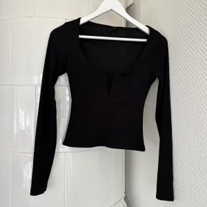 Topp - Långarmad topp från Gina Tricot med fin ringning framtill. Har använts några gånger och är i fint skick! Bra ordentligt tyg, inte genomskinlig 🫶