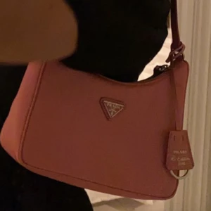 Prada re-edition nylon bag 2005 - Säljer nu min rosa prada bag, den är använd men har mer o ge! Älthetsbevis och Dustbag tillkommer