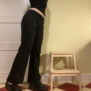 Kostymbyxor - lågmidjade kostymbyxor, kritstrecksrandiga, väldigt mjuka och bekväma! Snygg knäppning med två knappar och snygga kostymfickor där bak. Mått: 44 rakt över, Innerben 75, ytterben 97. Köpte 2ndhand, bra skick! 