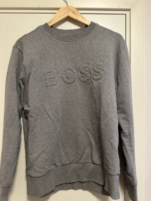 Hugo boss tröja ÄKTA - En jättefin hugo boss tröja i färgen går och i storlek L men passar även M. Äkta självklart, men osäker om jag har kvittot kvar