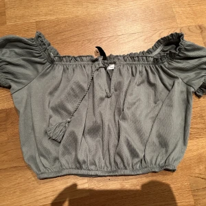 Unik topp - En fin moss-grön topp med coola detaljer. Kan även användas som off-shoulder 