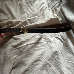 Skärp  - Säljer ett Ralph lauren skär som köpt för tre år sen och använt få gånger, i fint skick. Det är i färgen brun med gult detalj.