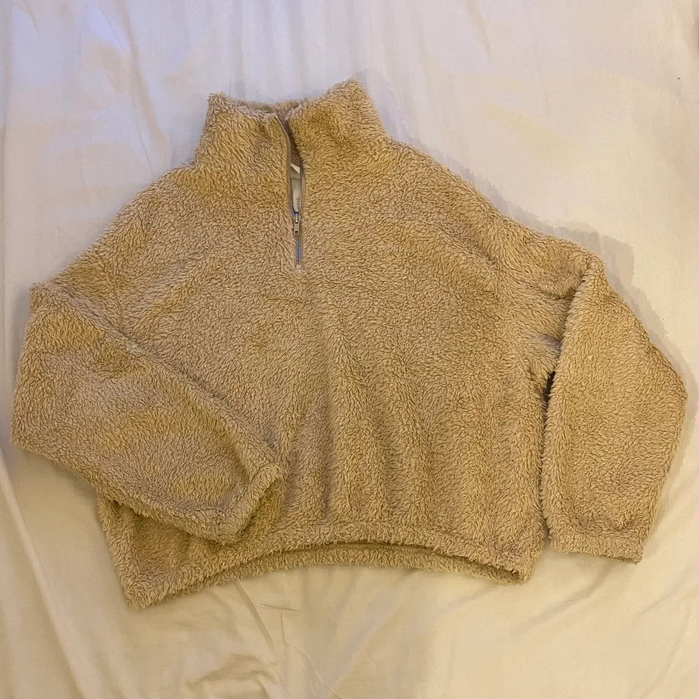 Beige fluffig tjocktröja från H&M i storlek M med dragkedja halvvägs. Använd fåtal gånger därav nyskick. Säljer pga att den inte kommer till användning.. Hoodies.