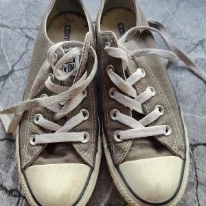 Converse  - Grå och vita låga Converse, storlek 36,5. 23 cm. Fina icke-slitna sulor och tyg. Lite missfärgningar som nog går att tvätta bort på sidorna av sulorna. Fula inuti då jag haft en inläggssula i dem, men den syns inte om man lägger i en 
