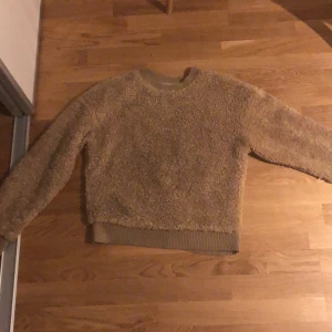 En långarmad tjocktröja. Storlek xs - En långarmad tjocktröja bra att ha i höst storlek xs färg beige brun tjocktröja.