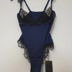 Blå body - Sensuell body i marinblått med svarta spetsdetaljer. Superfin! men jag råkade beställa flera... 🙄 Skulle säga att den i bysten troligen gör sig perfekt på en 75B-C och därkring.  Helt ny och oanvänd med lappar + skyddsplast kvar 🤗