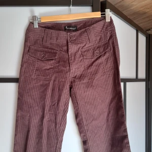Manchesterbyxor  - Vinröda/lila/bruna? Manchesterbyxor med lite coola detaljer, lowwaist, raka/lite flare- för små för mig| midjemått: ca 33cm, innerbenslängd: ca 80cm, midjehöjden: ca 20cm