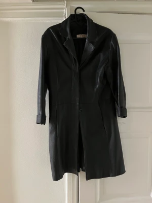 Läderjacka  - Fejk-läder. Mittenknapp saknas