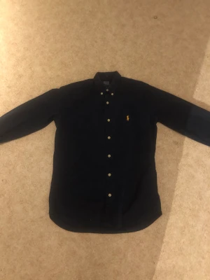 Polo Ralph lauren skjorta  - Mörkblå Ralph lauren skjorta. Perra till sommaren eller skolan eller fest eller vad man känner för. Bra skick, inga defekter eller fläckar!