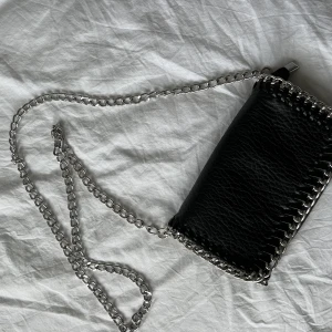 Svart väska  - Superfin svart lite mindre väska som är riktigt fin. Den är som i nyskick och har två innerfickor (en med dragkedja). Den har avtagbara kedjeband och kedjan är hyfsat lång så den är till för att ha tvärs över kroppen. Den är köpt på Scorett. 