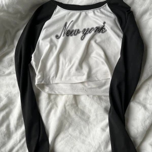 Kort långärmad magtröja  - En kort långärmad magtröja med text på 