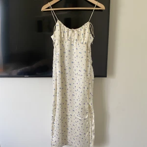 Blommig klänning - Jättefin sommarklänning från nakd, endast använd en gång men tyget har fått skador på rygg/rumpa (se bilder) därav billigt pris🫶🏼