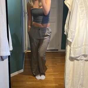 Snygga rutiga kostymbyxor  - Snygga rutiga kostymbyxor/tygbyxor med snett knäppe som detalj. Så snygga men kr ej till användning. Strlk 38