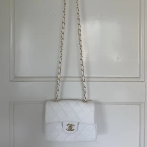 Väska - Chanel inspirerad väska i vit med gulddetaljer. Aldrig använd så är i nyskick.