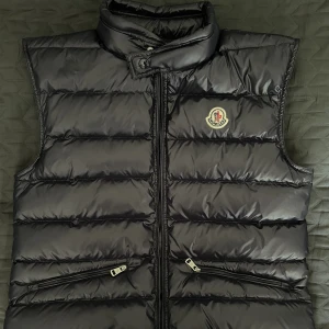 Moncler gui väst  - Västen är använd varsamt under en kort period men är i nyskick ändå. Storleken är 2 vilket motsvarar medium.
