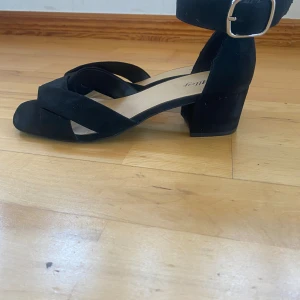 Klackskor  - Perfekta skor till skolavslutningen eller andra tillställningar i sommar. Svarta klackskor med bred och låg klack. De är super enkla att gå i. Använda några tillfällen.  Storlek 38. Går att justera vid ankeln. Något slitna på ena skon insida (bild 3.