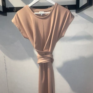 Bru nklänning - Brun klänning köpt från bubbleroom, knytes i midjan för att man skall få en fin form runt midjan