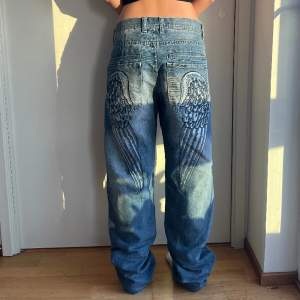 Coola jeans med målade änglavingar på bakfickorna 🌟Sitter ganska stort på mig men blir fina med ett bälte! 🌟 För referens är jag 163cm lång 🌟