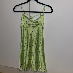 Fin sommarklänning  - Fin sommarklänning med blommor i satin. Nästan oanvänd.