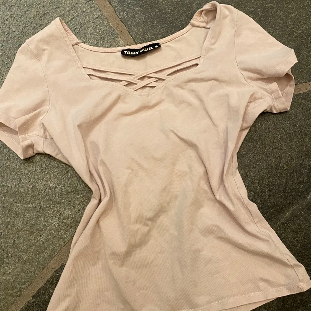 En supergullig ljusrosa T-shirt med detaljer i kragen🩷 tröjan är använd ett fåtal gånger och är därmed i mycket bra skick! T-shirten är i strl M (passar xs/s) och från märket Tally Weijl💋. T-shirts.