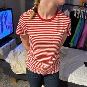 Röd/vitrandig t-shirt från Levi’s med ficka på bröstet. Bra skick och skönt material! Säljer då jag inte använder så mycket randigt längre. Produkten finns inte i sortimentet längre:)