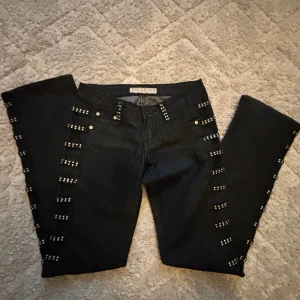 Svarta jeans med nitar - supeeer coola jeans med paljetter på. De är Bootcut och långmidjade. Jag är 162cm! Midjemått 37/38cm Innebenslängd 83cm Lår 24/25cm