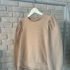 TRÖJA - En perfekt tröja nu när det är lite kallare från Pieces. Tröjan är beige med puffiga armar och är väldigt mjuk inuti. Tröjan har aldrig används och är i jättebra skick.