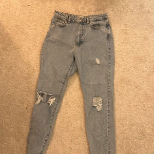 Jeans - Ljusblåa jeans med hål, lite baggy men tighta vid vaderna ( alltså inte tjafs ) 