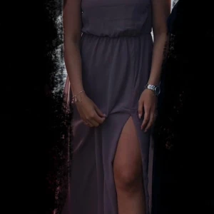 Fest/ balklänning - Super fin långklänning, perfekt till balen eller festen. En mjuk, ”smuts” lila färg. Öppen rygg, med kors över ryggen (bild går att få). 