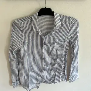 En basic blårandig skjorta ifrån Pull & Bear. Skjortan är i storlek S men är lite mindre i passformen. Den är i bra skick.