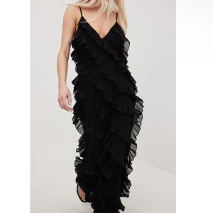 NA-KD Frill maxiklänning svart - Jättefin svart långklänning som passar jättebra till balen. Tyvärr kom den inte till användning så prislappen sitter kvar! 