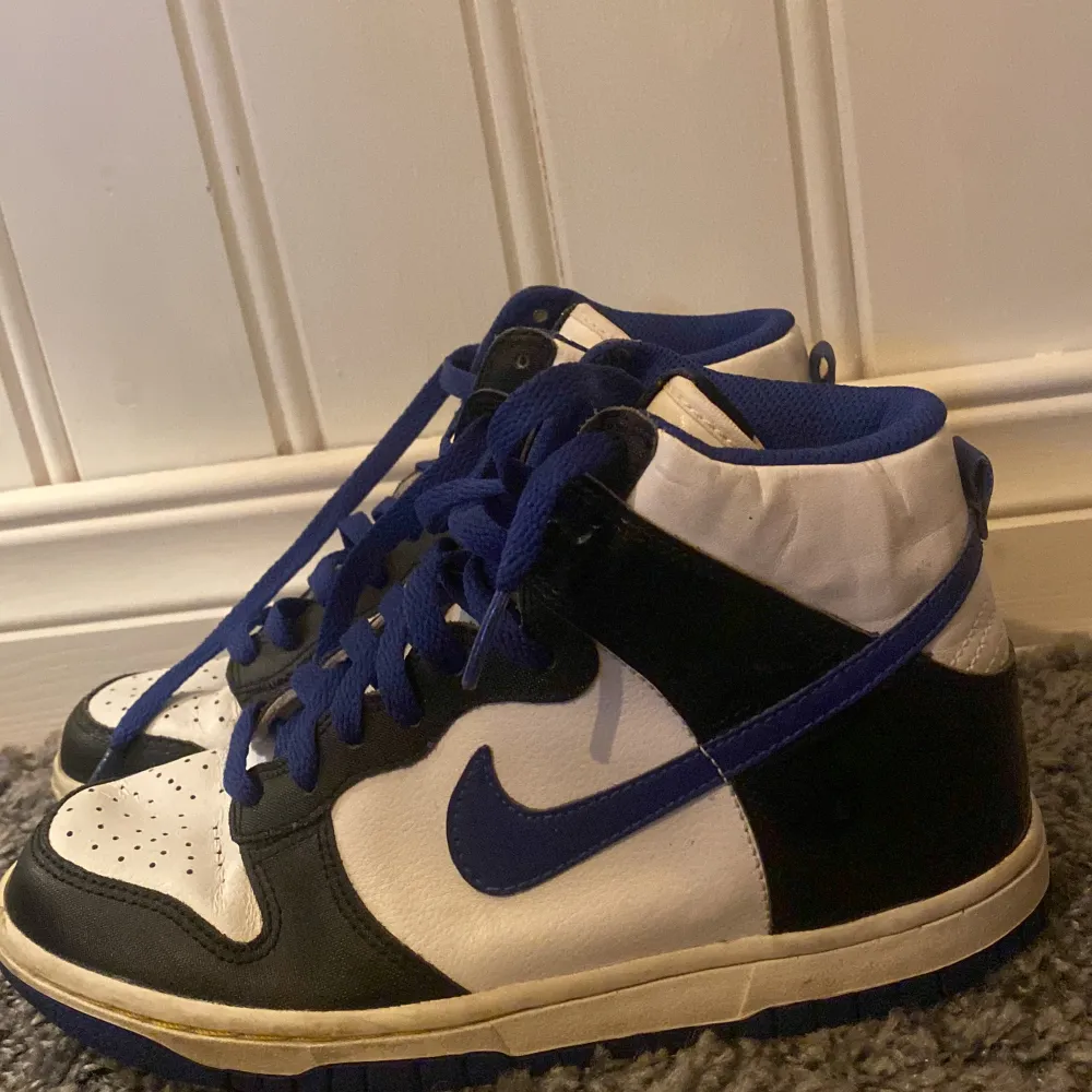 Det här är ett par 100% äkta Nike dunk high med färgerna svart, vit och blå. De är storlek 36.5 och saknar lådan skicket är acceptabelt men de är ganska creasade.. Skor.