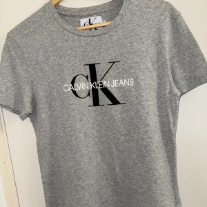 Calvin Klein T-Shirt - Superfin Calvin Klein T-shirt storlek M, passar S. Säljer pga det inte är min stil längre och den har aldrig använts, skicket är som nytt. Bara legat i garderoben. Hoppas någon annnan får användning av den. 