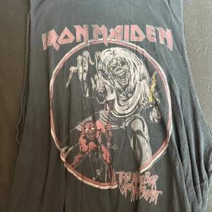 Säljer detta snygga Iron Maiden linnet som jag köpt för många år sedan, men som jag tyvärr inte har använt så ofta. Så linnet är i fint skick.   Storleken är M, men då linnet är långt så kan det kännas som en storlek större.