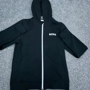Hugo boss hooded cardigan - Nu säljer jag denna Hugo boss hooded cardigan. Denna zip hoodie är använd ett väldigt fåtal gånger och är i skick 10/10. Nu säljer jag denna för 349kr!! nypris 1200kr. Hör av er vid funderingar. Kan gå ner i pris vid snabb affär🙌🤝
