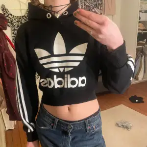 Cropad hoodie från adidas. Den slutar strax innan naveln, inte nopprig. 