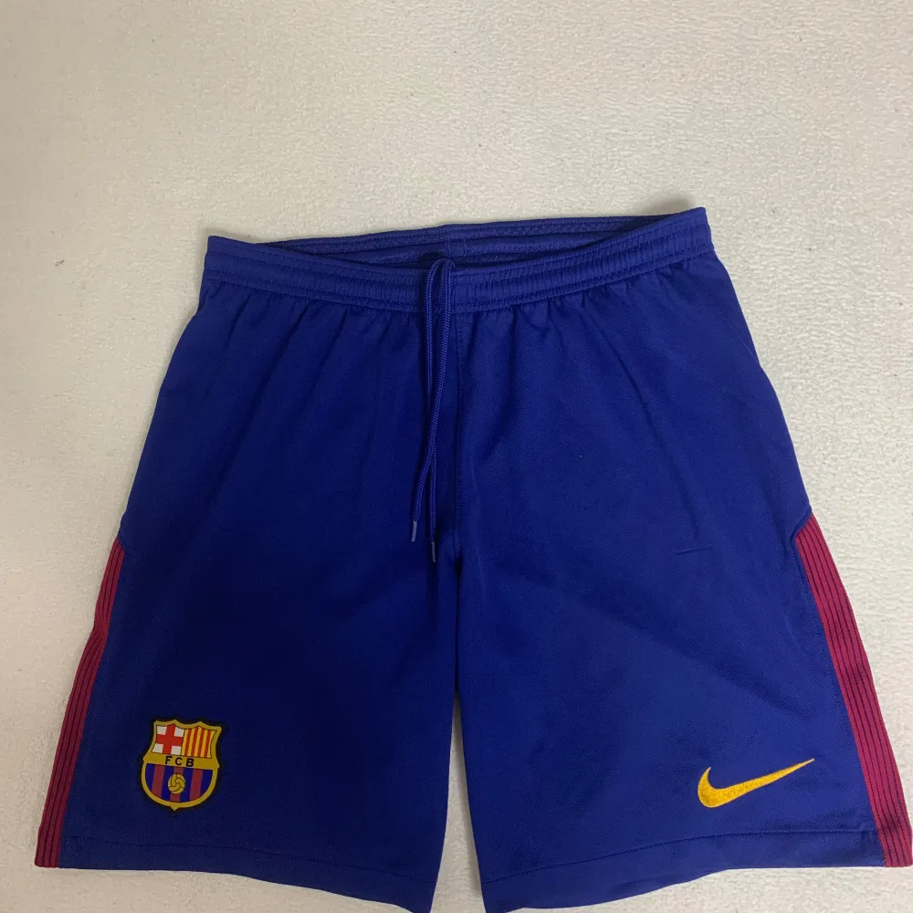 Hej, har nu ett par fina FC Barcelona shorts till salu från säsongen 2017. Den är i storlek S och köptes i FC Barcelonas fanshop i Barcelona själv! Shortsen är i bra skick men synlig använd. Ta din chans och köp snygga, äkta och billiga FCB shorts!. Shorts.