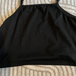 Svart linne  - Den är kort. Jag har strl 134/140 och den är ganska kort på mig. Den är upp till naveln. Det är bortklippt där uppe så jag kan ej se storleken. ❤️ knappast använd 