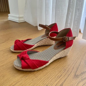 Röda klackskor - Snygga klackskor med en rosett. Knappt använda.