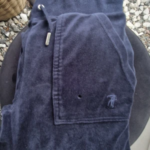 Juicy Couture mörkblå byxor - Mörkblå juicybyxor stl xxs. Fint skick med undantag av ett litet hål fram på fickan, se bild. Obs - byxorna är uppsydda, innerbensmått 69 cm.