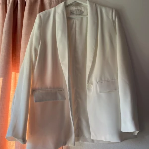 Vit kavaj - Vit kavaj från Nelly, aldrig använd. Väldigt rak passform. Storlek S