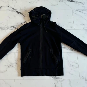 Cp Company hoodie med dragkedja  - Väldigt fin Cp Company tröja som använts ett fåtal gånger. 9.5/10 i skick. (Personen på bilden är 182 och väger 65 kg) Hör av er om ni har några frågor!