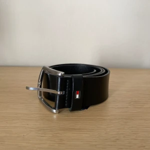 Tommy hilfiger bälte  - Säljer ett svart läderbälte ifrån Tommy hilfiger. Välj mellan 5 olika spännhål. 85 cm långt.  Nypris 999kr Mitt pris 229kr