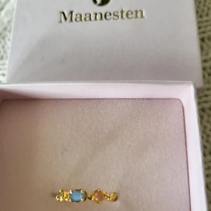 Maanesten ring - Nyskick.  Nypris 900 kr Vacker och unik vågig ring med persika månsten, labradorit och grön zirkon.  Material: 18K guldpläterad sterling silver 925